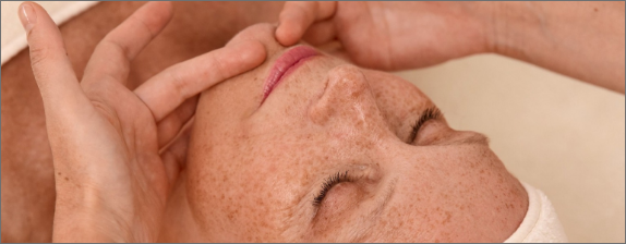 Cliente détendue pendant un soin facialiste, moment de lâcher-prise